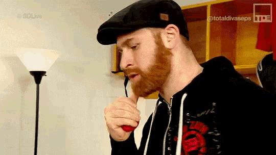 a man with a beard wearing a black hat and a black hoodie