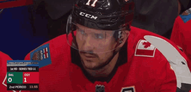 a hockey player with his eyes closed looks at a scoreboard
