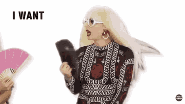 a drag queen is holding a megaphone and saying `` i want contact '' while wearing a wig and sunglasses .