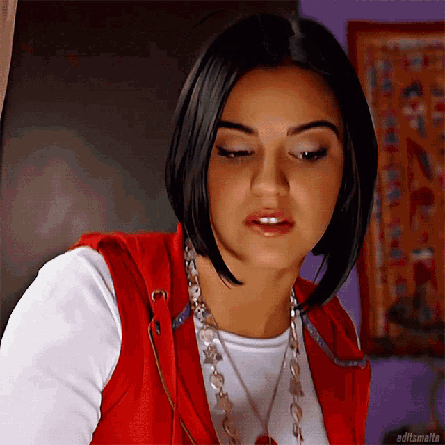 a woman wearing a red vest and a white shirt with editsmalte on the bottom