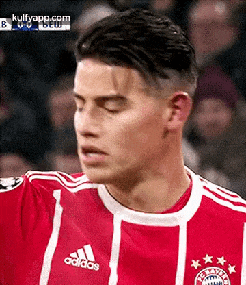 a close up of a soccer player wearing an adidas shirt .