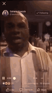 a man is standing in front of a crowd of people on a facebook live video .