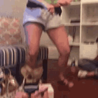 a woman is dancing in a living room while wearing shorts