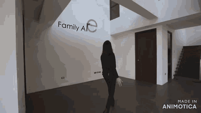 a woman is standing in front of a wall that says family ale