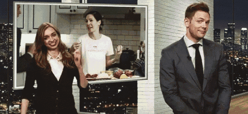 a man in a suit and tie is standing next to a woman in a white shirt that says ' nespresso '