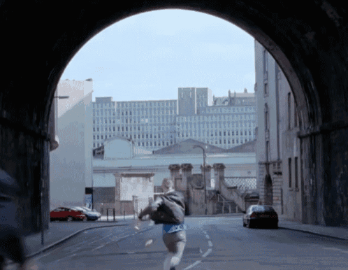 a person running through a tunnel with a building in the background that says ' a ' on it