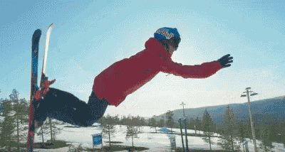 a person wearing a red bull helmet is doing a trick on skis