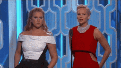 amy schumer and jennifer lawrence are standing next to each other on a stage