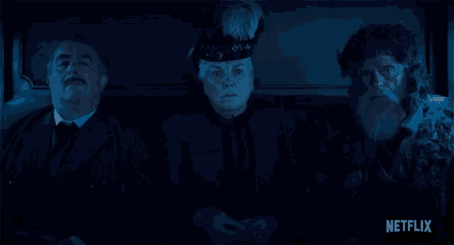 three people sitting in a dark room with a netflix logo on the bottom