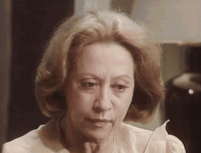 a close up of an older woman 's face with a serious look on her face
