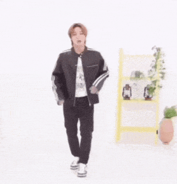 a man in a black jacket and black pants is dancing .