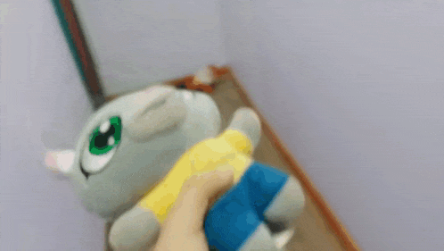 a person is holding a stuffed rabbit with blue shorts and a yellow shirt