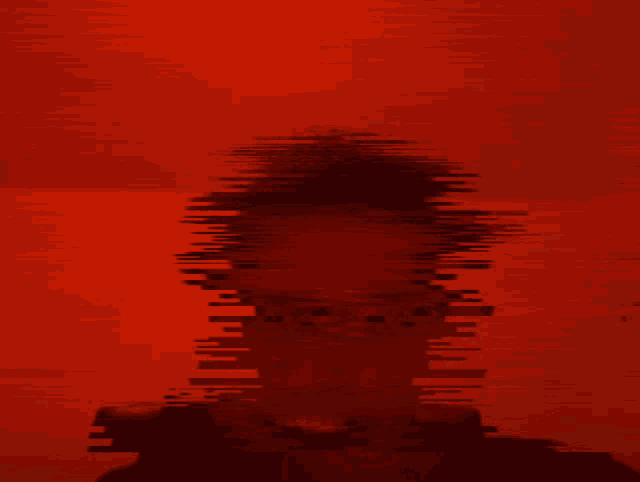 a red background with a silhouette of a person in the foreground