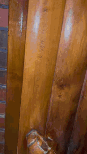 a close up of a wooden staircase with a brick wall