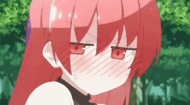 a close up of a girl with red hair and red eyes covering her mouth .