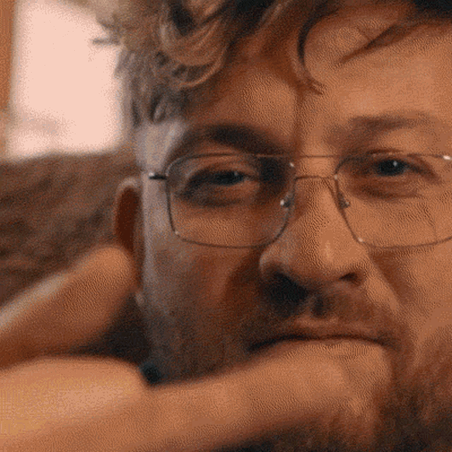 a close up of a man 's face with glasses