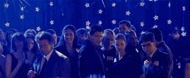 a group of people standing in front of a blue background with stars on it
