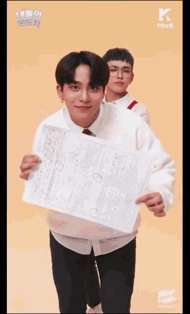 a man in a white shirt is holding a piece of paper