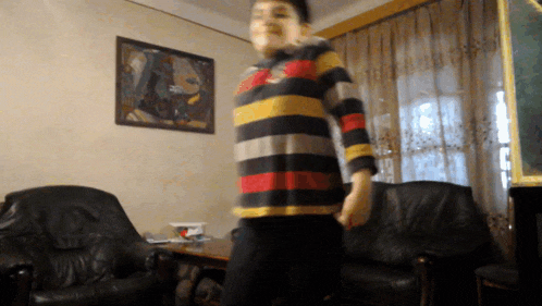 a person in a striped shirt is standing in a living room
