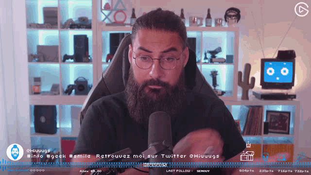 a man with a beard sits in front of a microphone