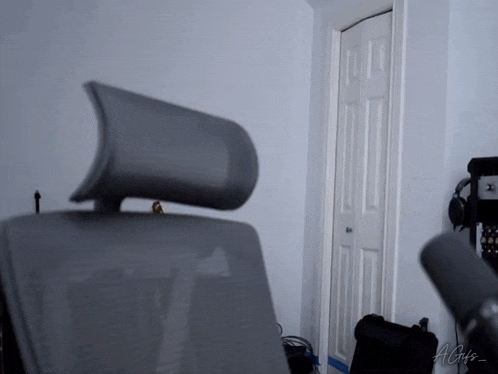 a chair with a headrest is in a room with a microphone and a sign that says agis