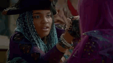 a woman with purple hair and a purple jacket is sitting next to another woman .