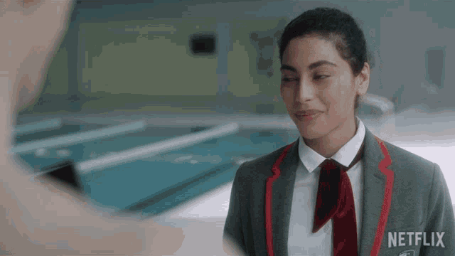 a girl wearing a netflix badge stands in front of a pool