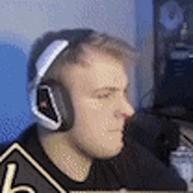 a man is wearing headphones while sitting in front of a computer .