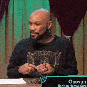 a bald man with a beard is sitting at a table with dice and a sign that says onovan