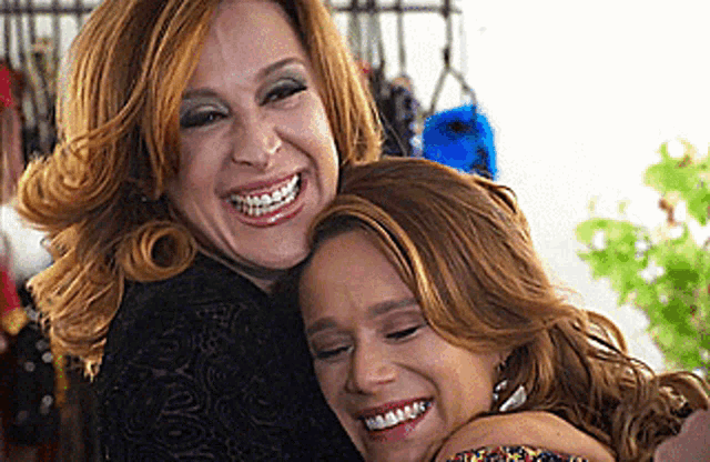 two women are hugging and smiling for the camera