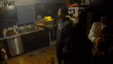 a man in a new york yankees shirt is standing in a kitchen