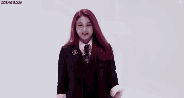 a woman with red hair is wearing a suit and tie and has a speech bubble around her head .