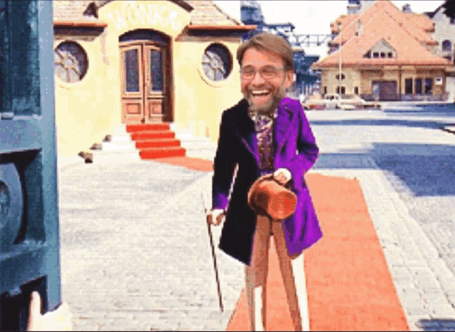 a man in a purple suit is standing in front of a building that has the word wonka on it