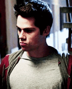 a close up of a man wearing a grey shirt and a red sweater