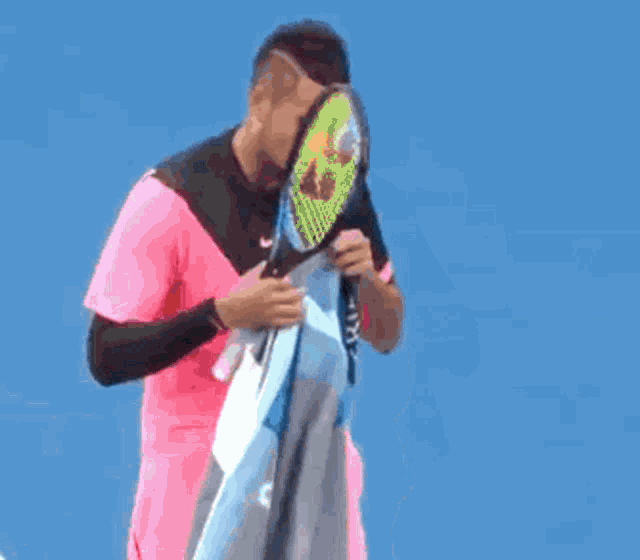 a tennis player wipes his mouth with a towel while standing next to a referee
