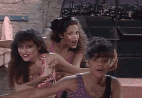 a group of three women are standing next to each other and one of them is holding another woman 's arm .