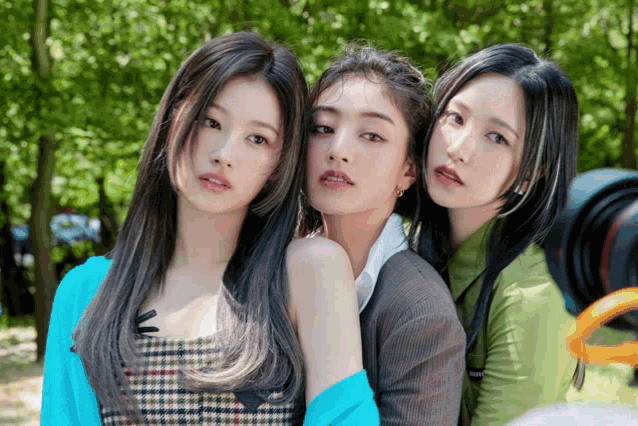 three girls posing for a picture with one wearing a plaid dress