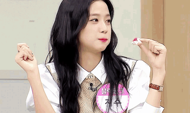 a woman with long black hair has a name tag that says jisoo