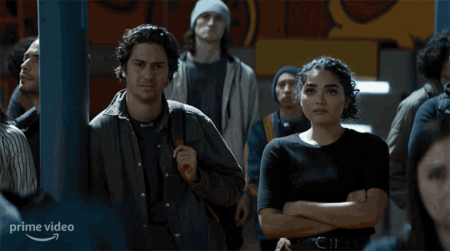 a man and a woman are standing in a crowd with the word prime video on the bottom left