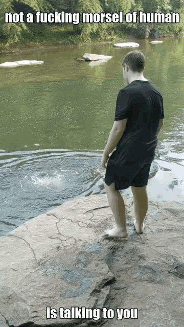 a man is standing on a rock near a body of water with a caption that says not a fucking morsel of human