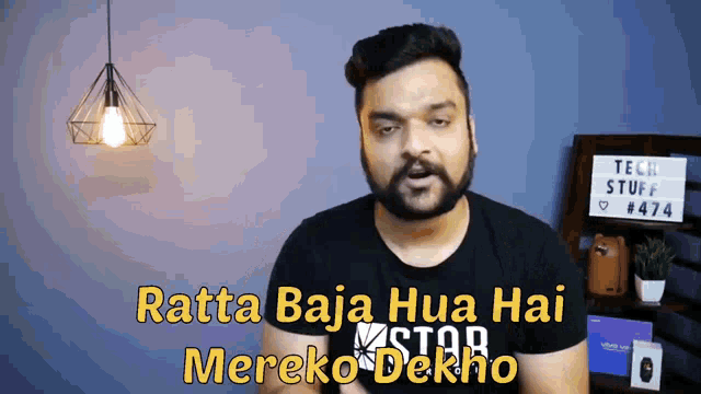 a man wearing a black shirt with the words ratta baja hua hai mereko dekho on it