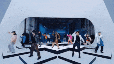 a group of people are dancing on a stage in a room .