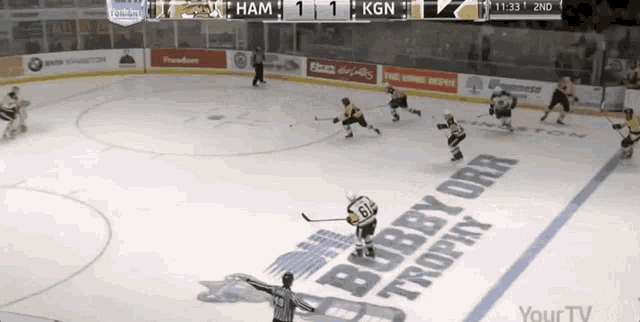 a hockey game is being played in front of a bobby orr trophy sign