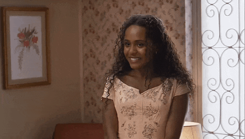 a woman in a pink dress is smiling in a living room