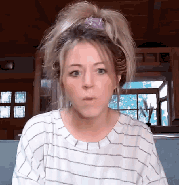 a woman in a striped shirt is making a face