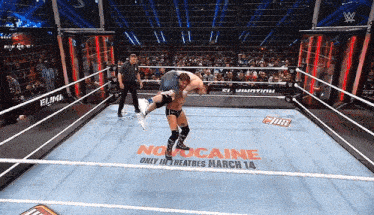 two men are wrestling in a ring with a sign that says no cocaine only in theatres march 14