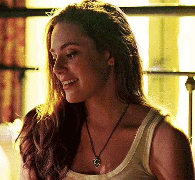 a woman wearing a necklace with a smiley face on it