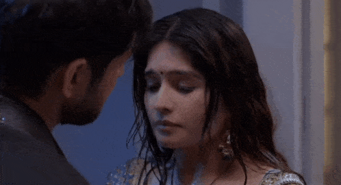 a man and a woman are kissing each other in a room .