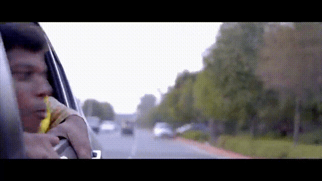 a man eating a banana while driving down a street