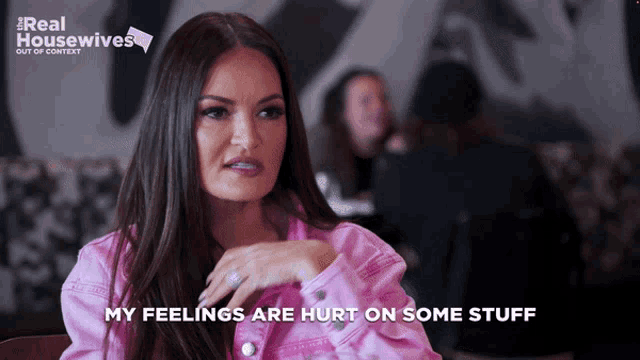 a woman in a pink jacket is talking about her feelings on some stuff
